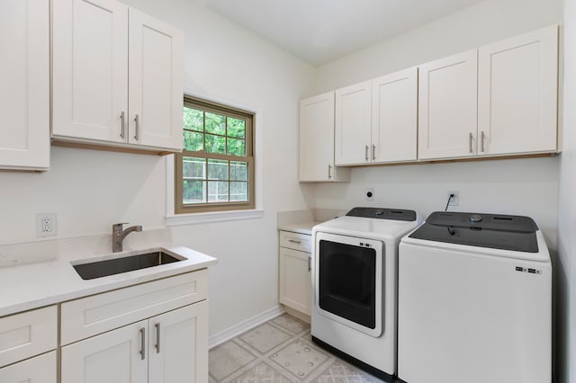 laundry room featuring cabinets, sink, and independent washer and dryer