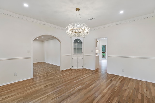 unfurnished dining area featuring ornamental molding, a chandelier, and hardwood / wood-style flooring