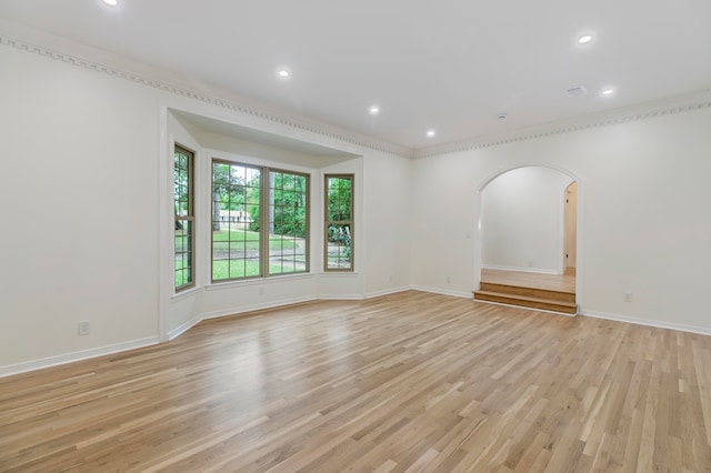 spare room with light hardwood / wood-style flooring and crown molding