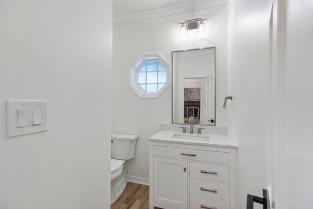 bathroom with ornamental molding, vanity, hardwood / wood-style floors, and toilet