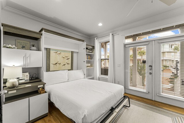 bedroom featuring french doors, ornamental molding, wood finished floors, and access to exterior