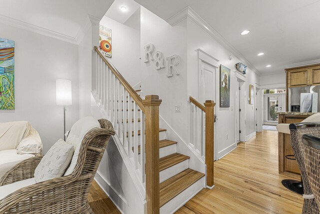 stairway with ornamental molding, recessed lighting, baseboards, and wood finished floors