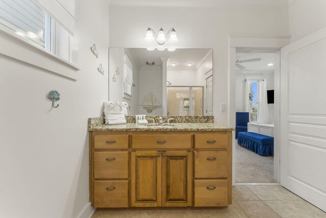 ensuite bathroom featuring a stall shower, a ceiling fan, tile patterned flooring, crown molding, and vanity