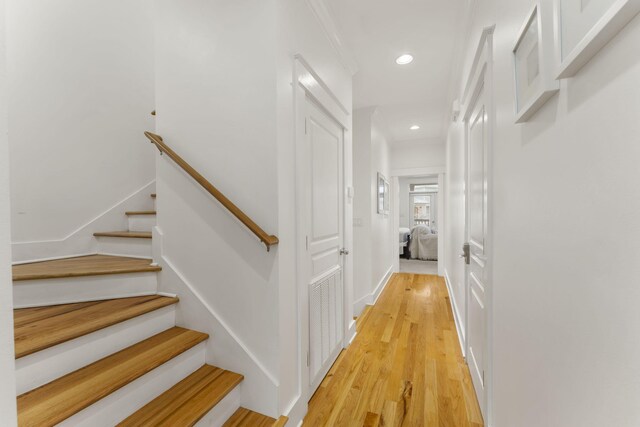 hall featuring visible vents, baseboards, light wood-style flooring, stairway, and recessed lighting