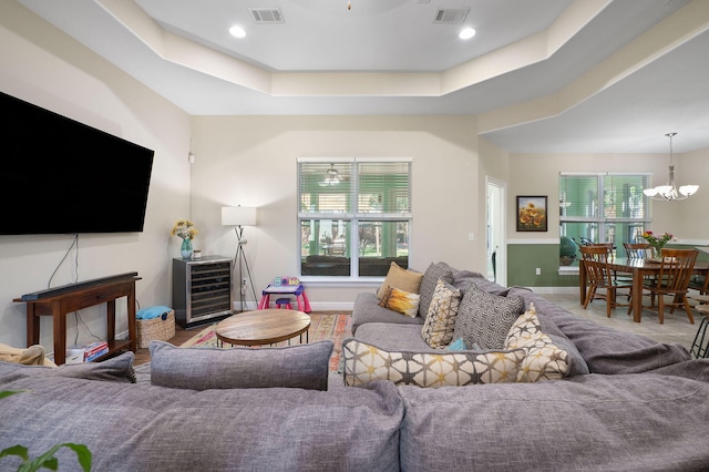 living room featuring a tray ceiling and a chandelier