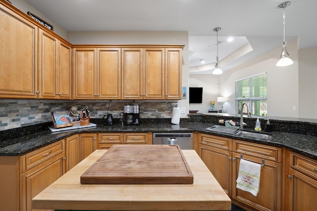 kitchen featuring stainless steel dishwasher, wood counters, hanging light fixtures, and sink