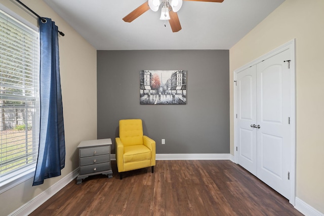 sitting room featuring ceiling fan and dark wood-type flooring