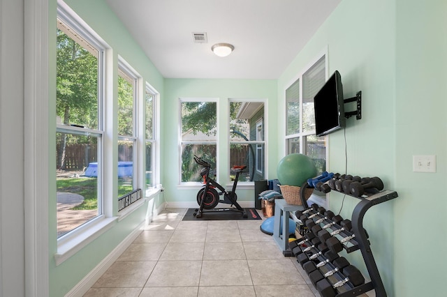 exercise area featuring light tile patterned flooring and a wealth of natural light