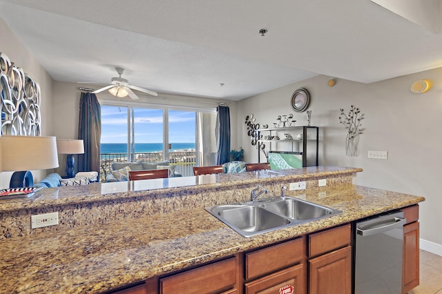 kitchen with light stone countertops, ceiling fan, sink, light tile patterned floors, and dishwasher