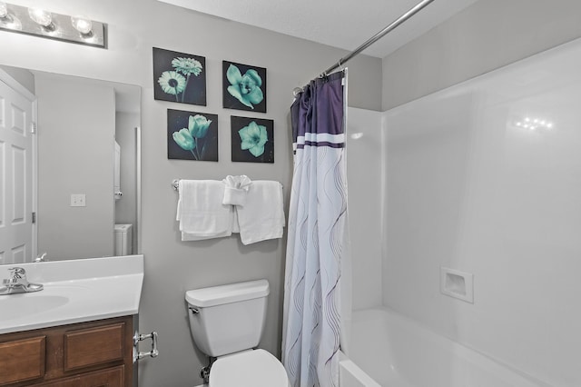 full bathroom featuring vanity, shower / bath combo with shower curtain, toilet, and a textured ceiling