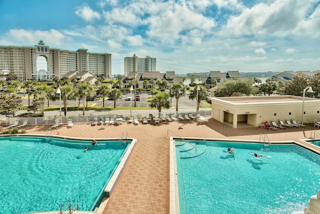 community pool featuring a patio and fence