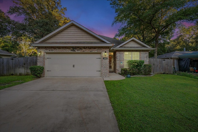 view of front of property with a garage and a yard