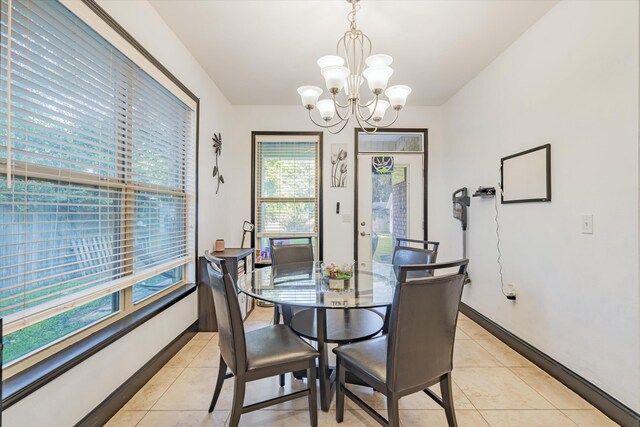 dining space featuring light tile patterned floors and a notable chandelier