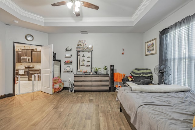 bedroom with light wood-type flooring, a raised ceiling, ornamental molding, and ceiling fan