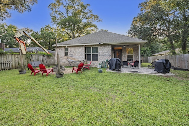 back of house featuring a yard, a patio, and an outdoor fire pit