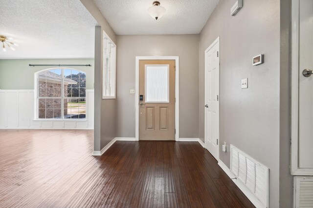 entrance foyer with a textured ceiling and dark hardwood / wood-style floors