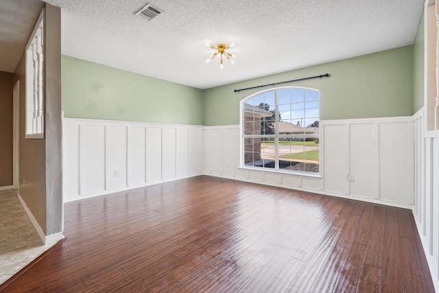 empty room featuring a textured ceiling and hardwood / wood-style floors