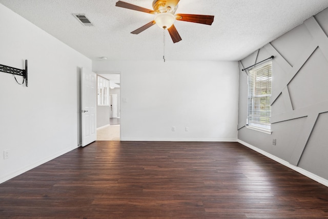 empty room featuring ceiling fan, a textured ceiling, and dark hardwood / wood-style flooring