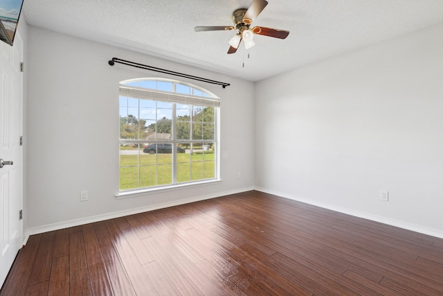 empty room featuring ceiling fan, a textured ceiling, and dark hardwood / wood-style flooring