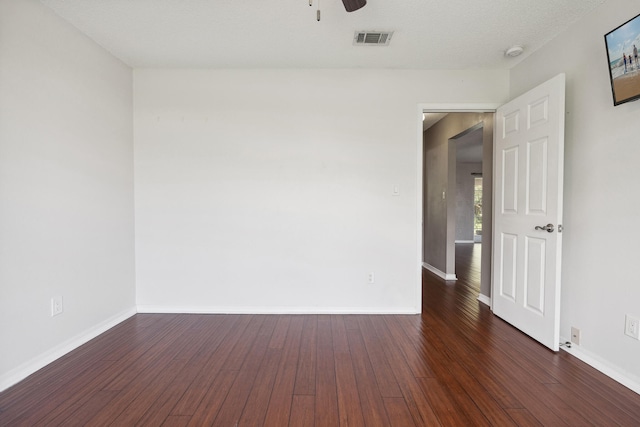 empty room featuring a textured ceiling, ceiling fan, and dark hardwood / wood-style flooring