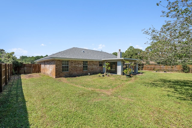 rear view of property featuring a lawn