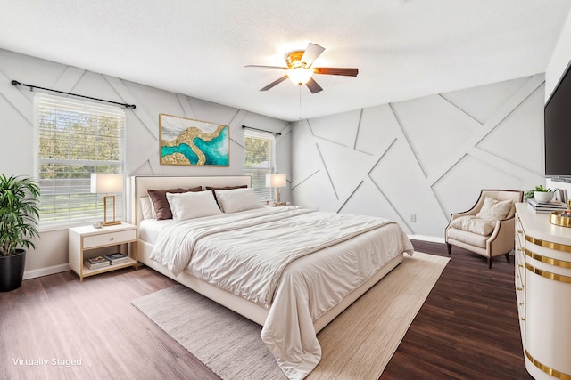 bedroom with a textured ceiling, dark hardwood / wood-style floors, and ceiling fan