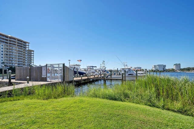 dock area with a lawn and a water view