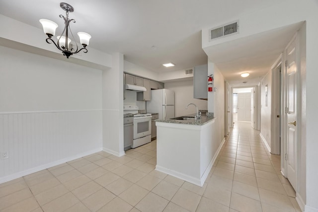 kitchen with sink, a notable chandelier, gray cabinetry, white appliances, and light tile patterned floors