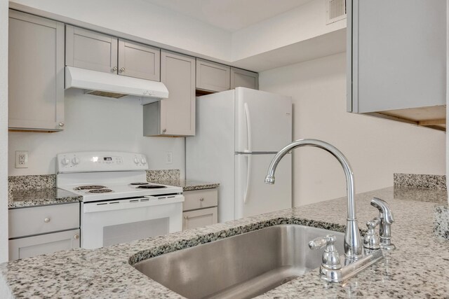 kitchen featuring gray cabinetry, white appliances, light stone counters, and sink