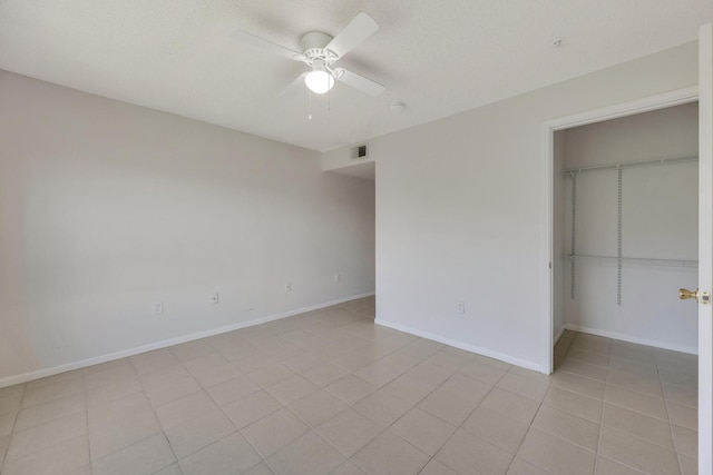 unfurnished bedroom featuring light tile patterned floors, ceiling fan, and a closet