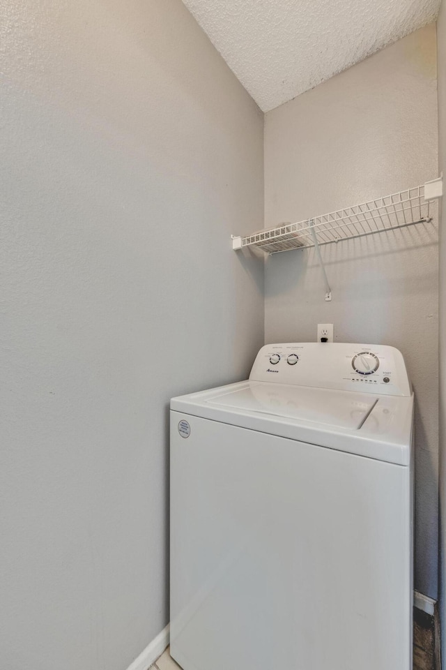 laundry area with a textured ceiling and washer / clothes dryer