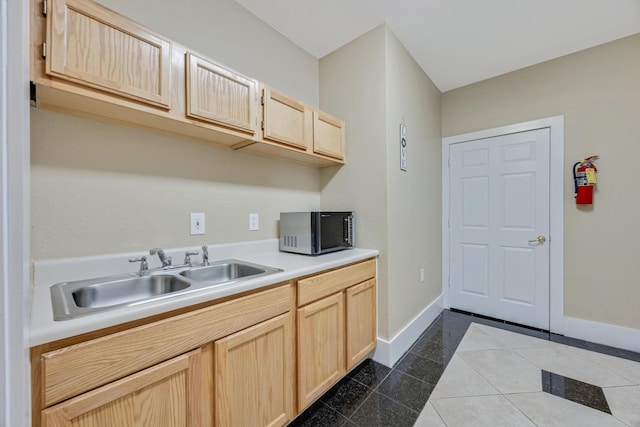 kitchen featuring light brown cabinetry, sink, and dark tile patterned floors