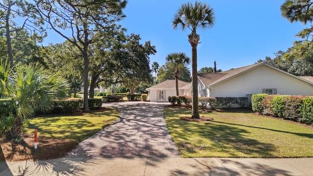 single story home with central air condition unit, a front lawn, and decorative driveway