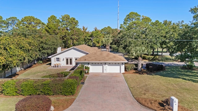 view of front of home with fence, an attached garage, driveway, french doors, and a front yard