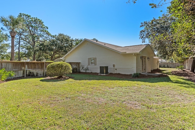 view of property exterior with central air condition unit, brick siding, a fenced backyard, and a lawn