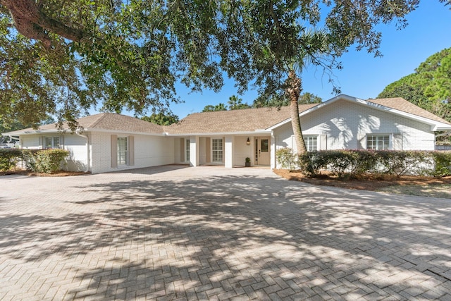 single story home with brick siding and decorative driveway