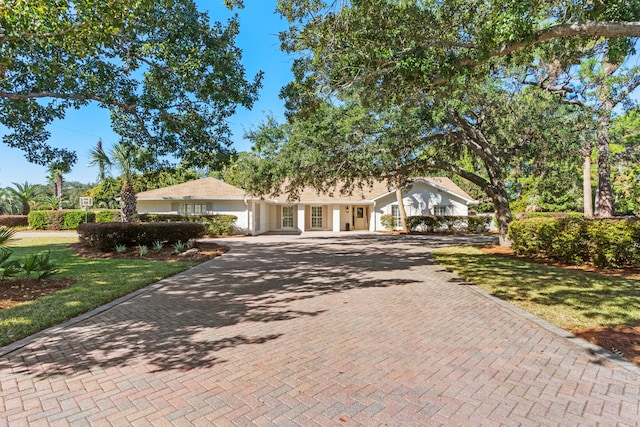 view of front facade with a front yard and decorative driveway