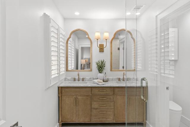 bathroom with vanity, toilet, and an enclosed shower