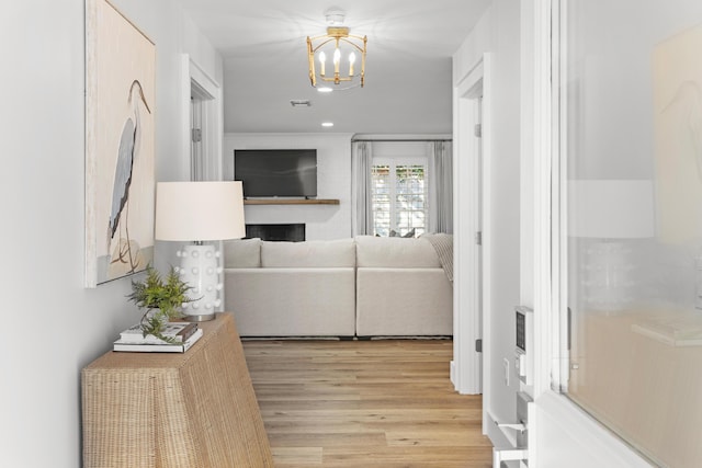 hallway featuring recessed lighting, light wood-type flooring, visible vents, and an inviting chandelier