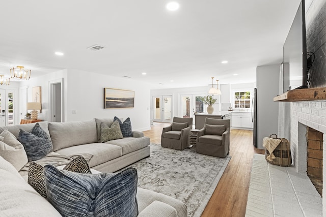 living room with a fireplace and light wood-type flooring