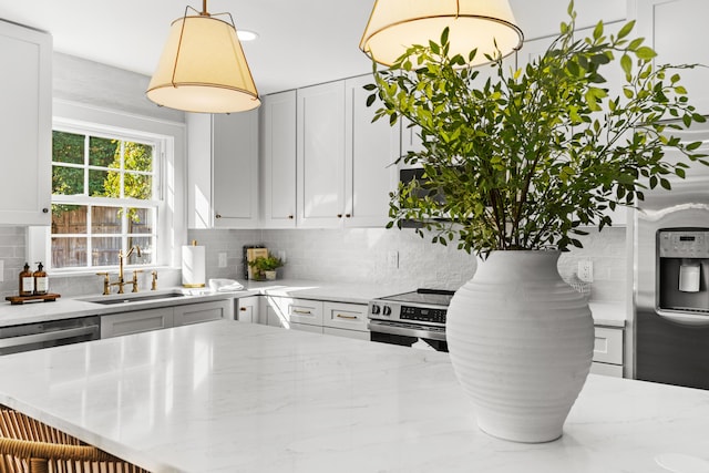 kitchen featuring a sink, dishwasher, backsplash, white cabinetry, and light stone countertops