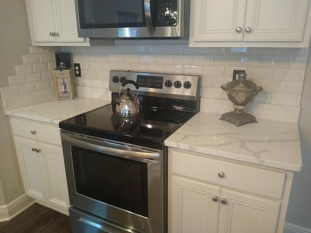 kitchen featuring light stone countertops, appliances with stainless steel finishes, dark hardwood / wood-style floors, and tasteful backsplash