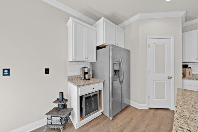 kitchen featuring stainless steel refrigerator with ice dispenser, light hardwood / wood-style floors, white cabinetry, and tasteful backsplash