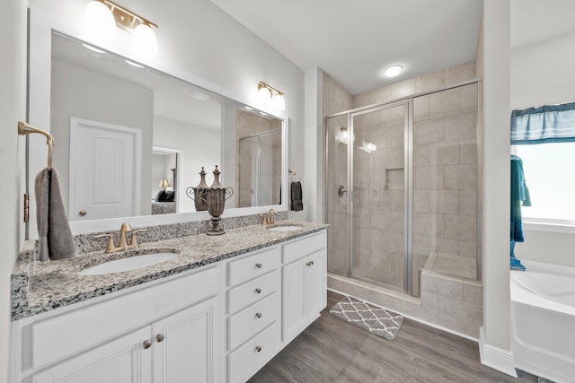 bathroom featuring vanity, plus walk in shower, and hardwood / wood-style flooring