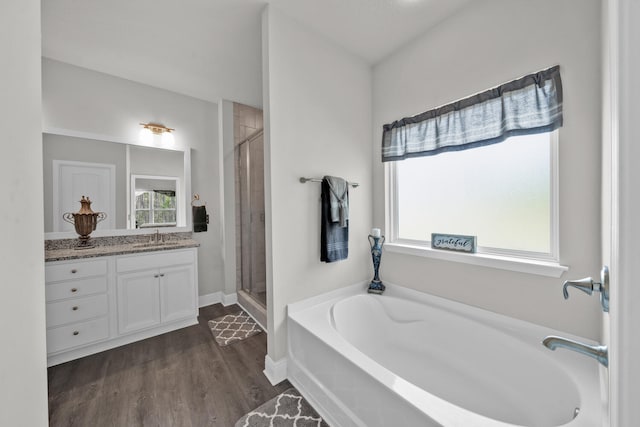 bathroom with independent shower and bath, vanity, wood-type flooring, and plenty of natural light