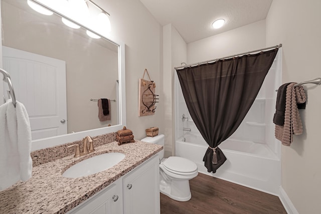 full bathroom featuring hardwood / wood-style floors, shower / tub combo with curtain, vanity, and toilet