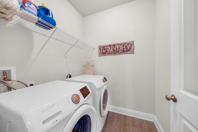 clothes washing area with hardwood / wood-style floors and washing machine and clothes dryer