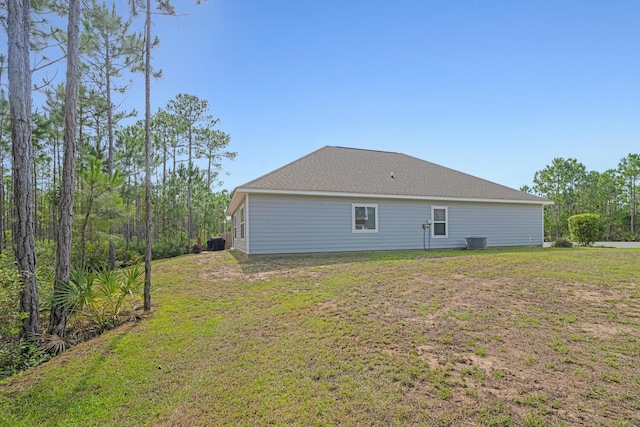 back of house with cooling unit and a lawn