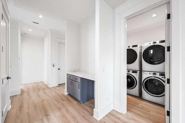 394 Grande Pointe Cir, Inlet Beach, FL 32461 - laundry room featuring light wood-style flooring, stacked washer and clothes dryer, baseboards, recessed lighting, and crown molding