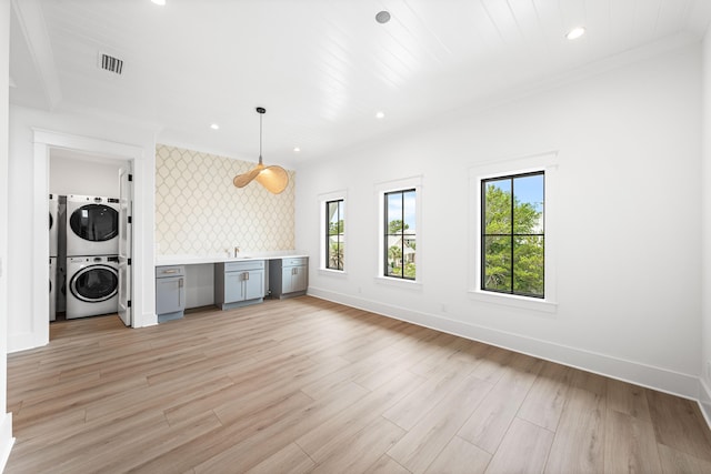 394 Grande Pointe Cir, Inlet Beach, FL 32461 - unfurnished living room featuring stacked washer / drying machine, baseboards, recessed lighting, light wood finished floors, and a sink